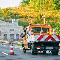 Truck carrying road safety cones on asphalt road of Slovenia