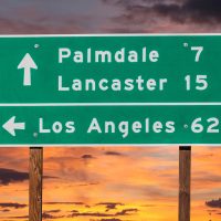 cartel de la carretera con indicaciones de distancia a Palmdale, Lancaster, Los Ángeles.