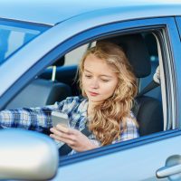 mujer usando su telefono mientras maneja