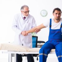 Young male contractor visiting old doctor