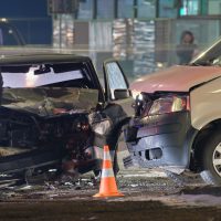 Cars crashed heavily in road accident after collision and silhouette of people on city street at night. Road safety and insurance concept