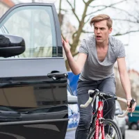 a-cyclist-narrowly-avoids-an-open-car-door-on-a-busy-street[1]