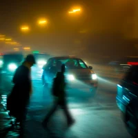 blurry-city-scene-at-night-with-cars-and-pedestrians-on-a-foggy-street[1]